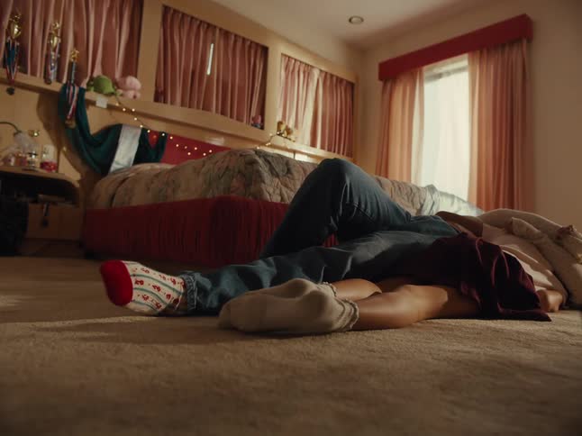 Teenage boy and girl lying on the bedroom carpet and hugging each other