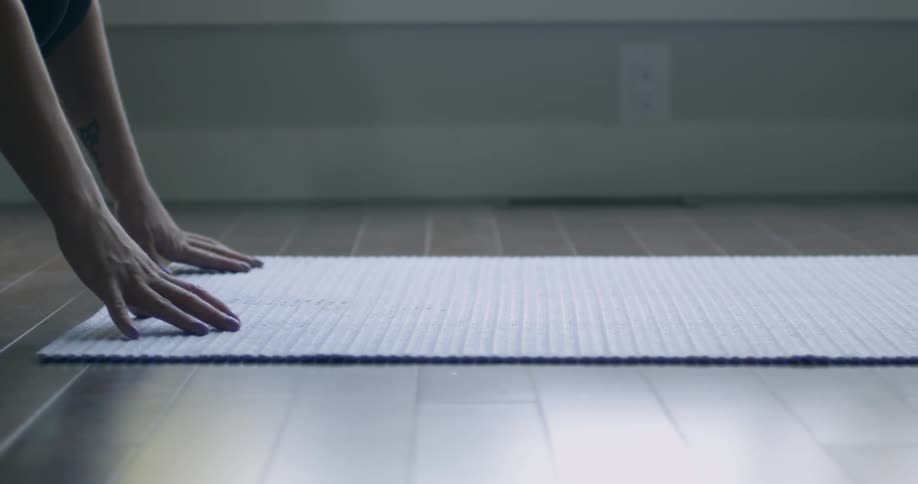 A person rolls out a yoga mat