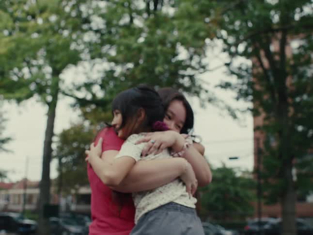 Two sisters hug and spin outside