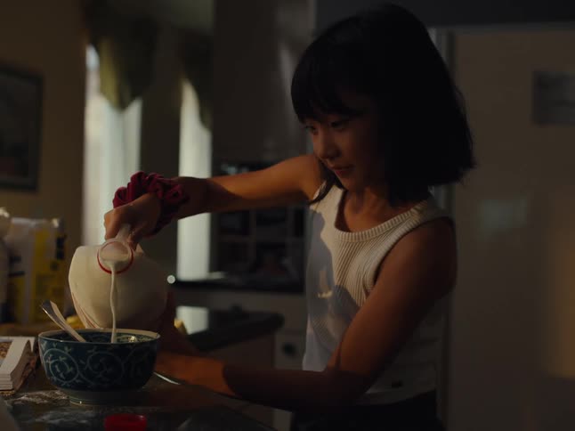 Girl pouring milk into a bowl