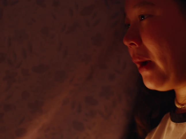 Two sisters play a game in the blanket fort