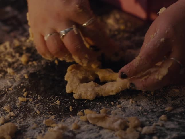 Hands with a mold preparing cookie dough