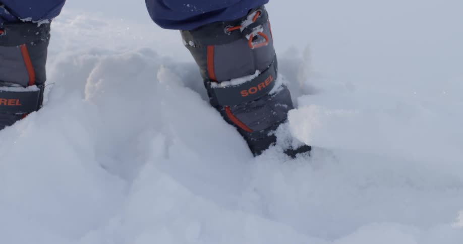 A person outside shoveling snow with a little red shovel