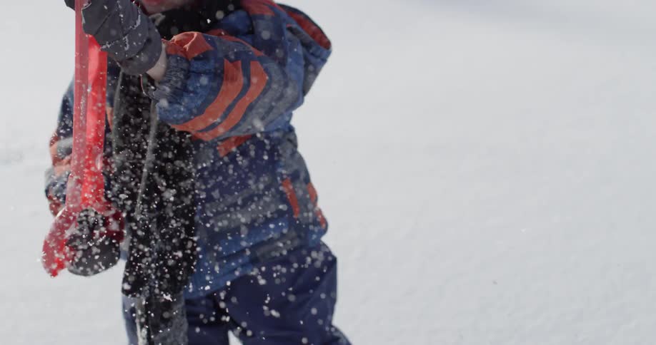 A young child shovels snow