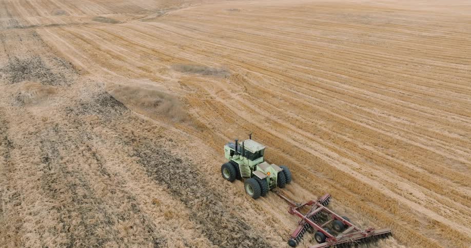 An aerial footage of a tractor in a farm