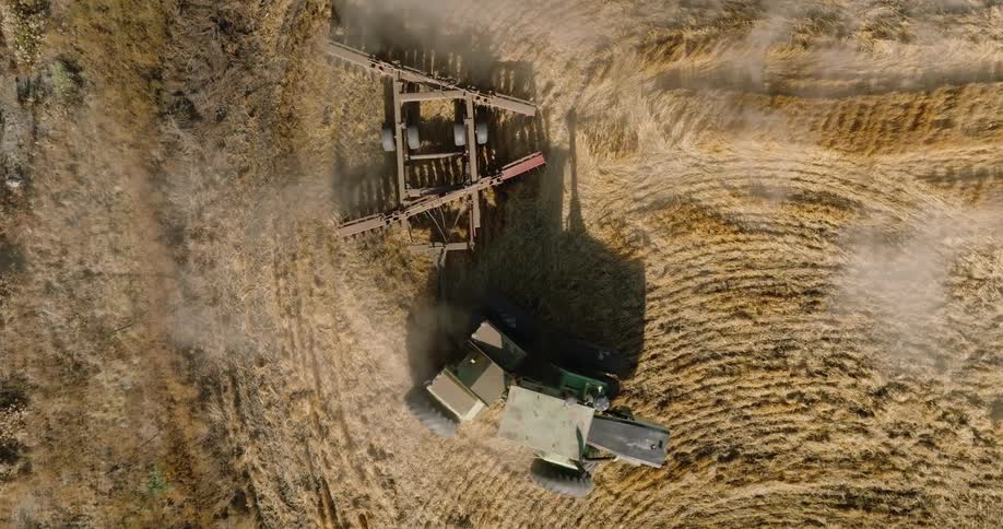 A tractor pulls a plow through a field