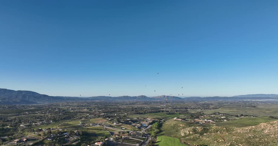 Hot air balloons hover over field