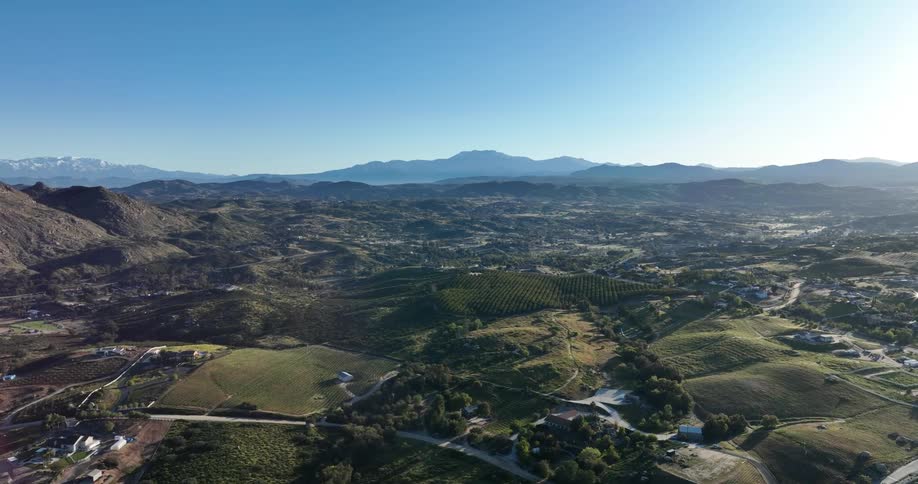 Aerial view of buildings in a countryside area with mountains surrounding