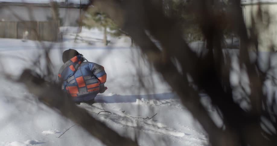 A child is shoveling snow in a yard