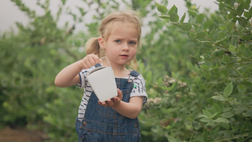 A child raises a container on the farm