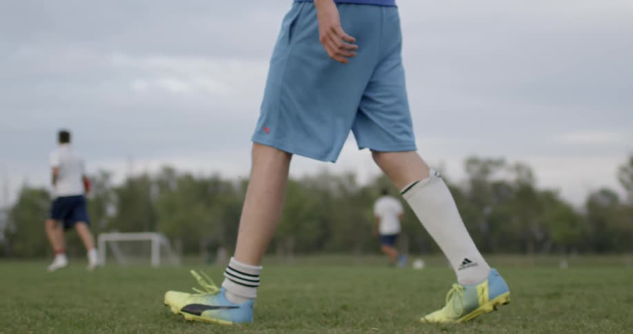 A group of men walking on a soccer field waiting to play