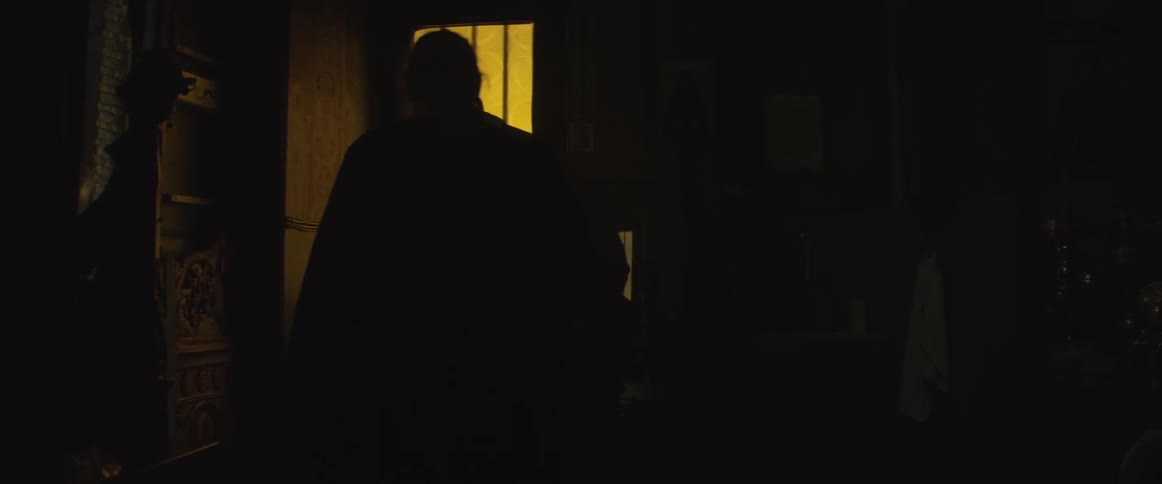 Man standing in a dark room holding an object