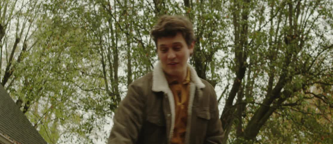 Cheerful man cleaning the yard with trees