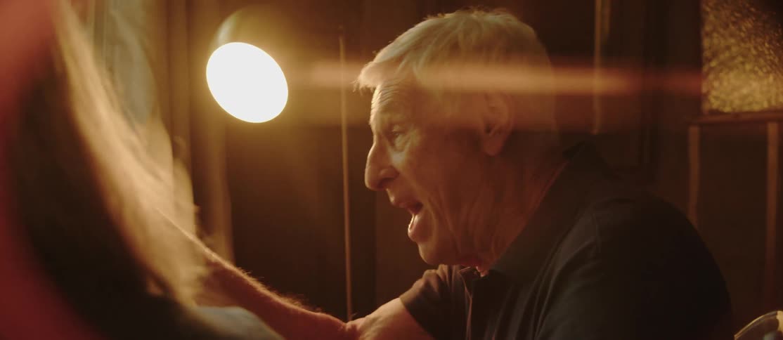 Elderly man in an indoor space laughing