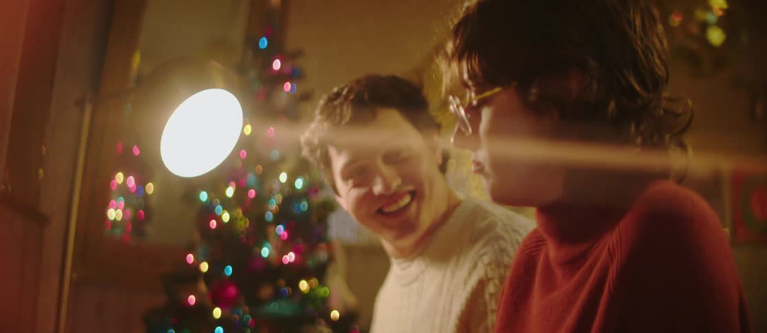 Man and woman sitting together in a christmas decorated room talking happily