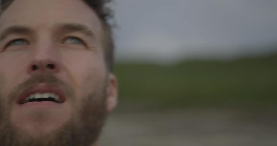 A bearded man throws a rock