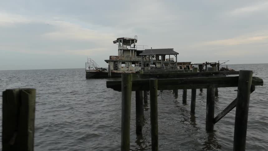 Water flows and ripples around an old pier