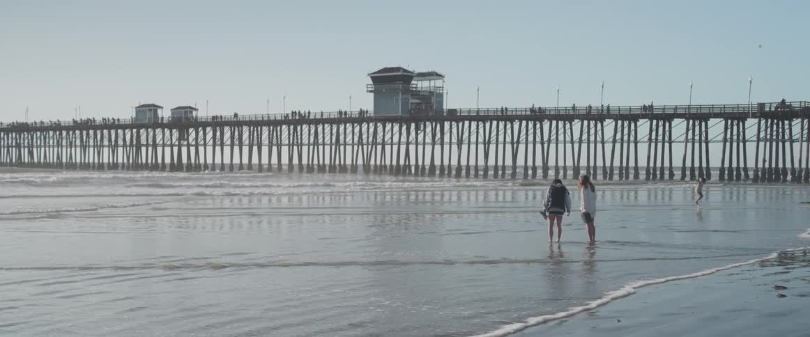 People are standing in the water on the beach