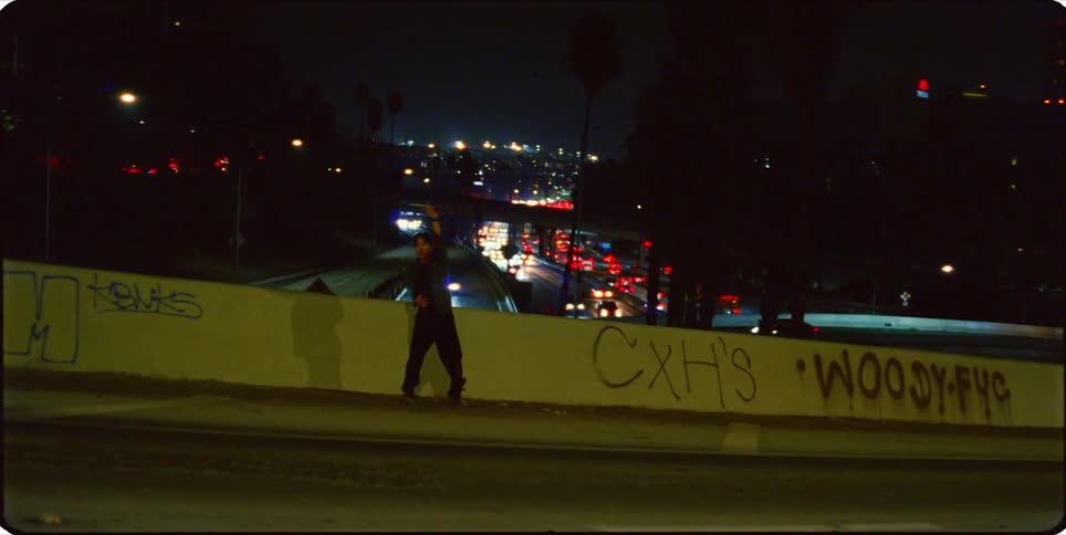 The man dances on the pavement a backdrop of complex highways illuminated under the night sky
