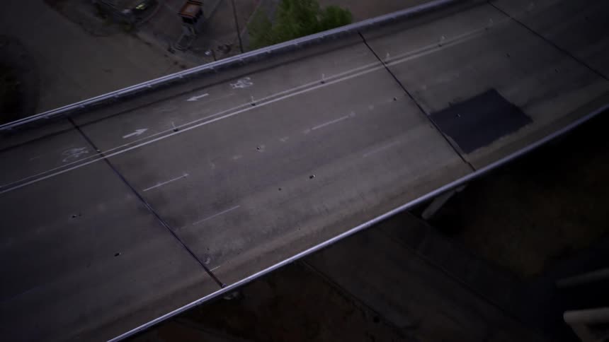An aerial clip of a bike passing under a bridge