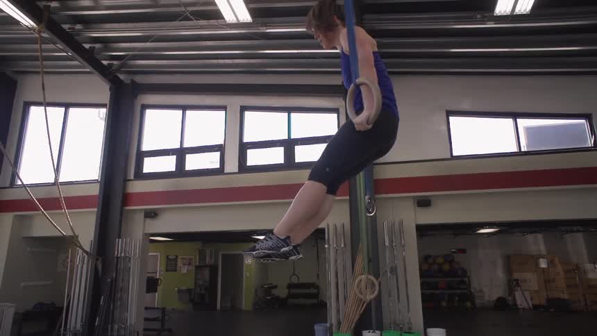 A woman doing ring pull-ups