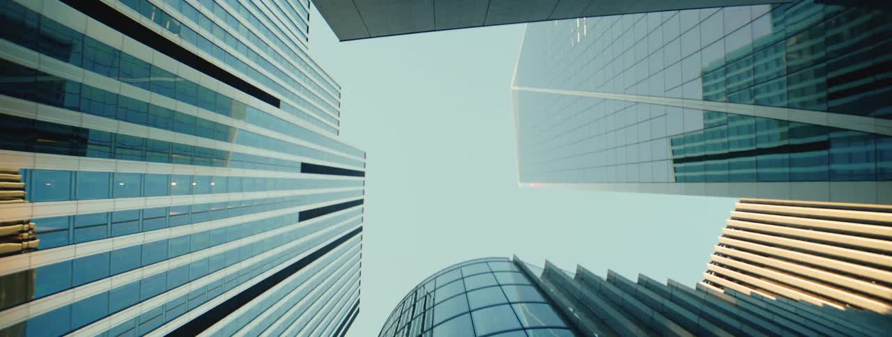 A view of tall modern office buildings with reflective glass facades reaching towards the sky