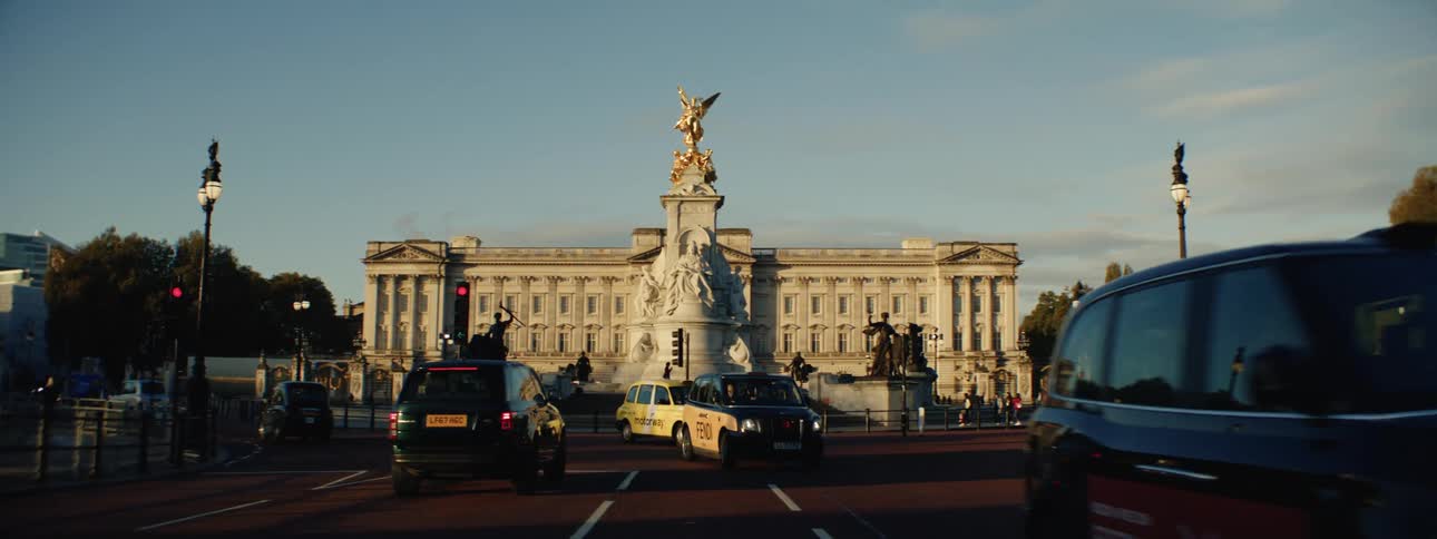 Classical statue of a square in a roundabout with traffic of people and vehicles