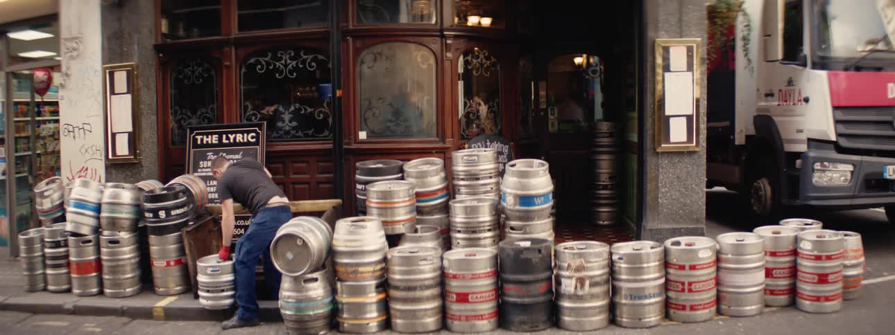 Man arranging metal containers in front of a store