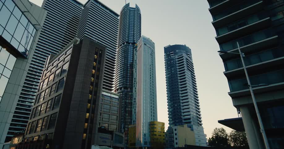 A cluster of towering skyscrapers pierce the sky their sleek silhouettes reflecting the fading light of day