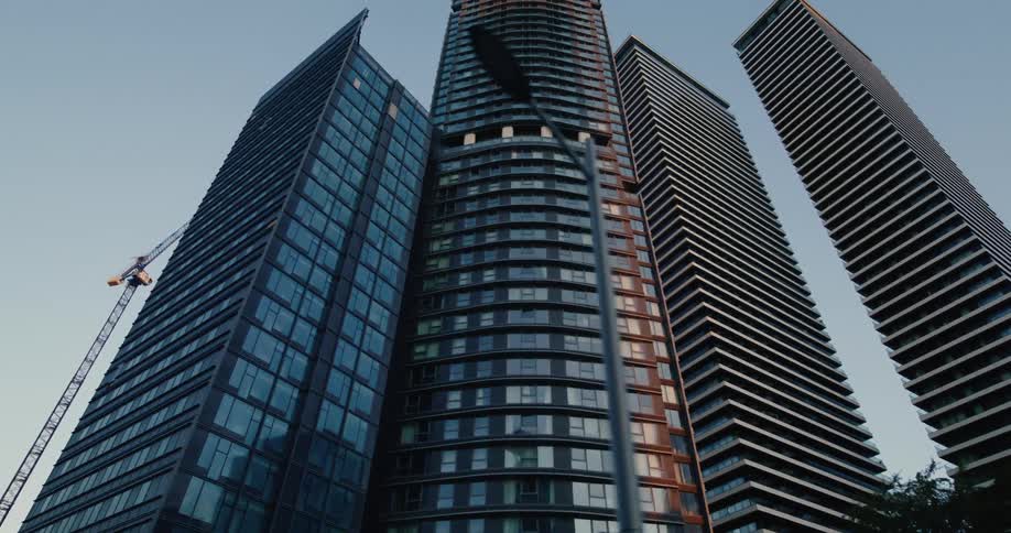 A cluster of tall modern skyscrapers reaching towards the sky their sleek facades reflecting the setting sun