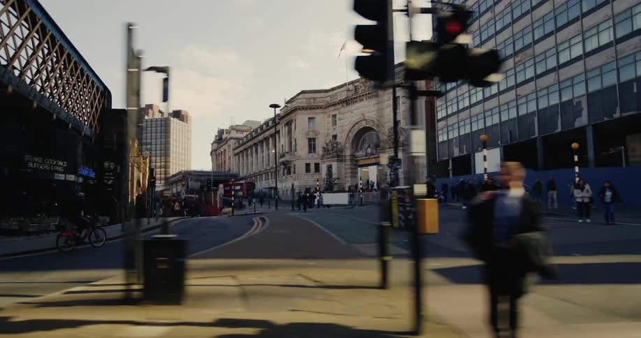 Person riding a bicycle in the middle of the streets of a metropolis with several pedestrians