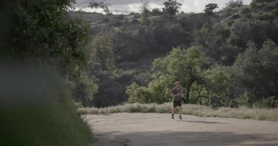 A man is running up a small hill