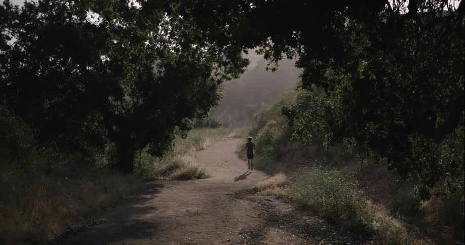 A jogger runs down a dirt trail