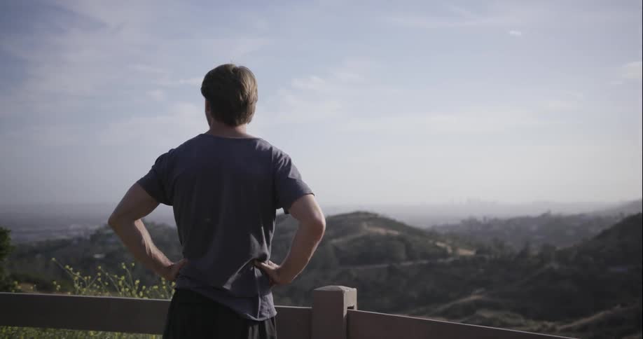 A man looks out over a valley