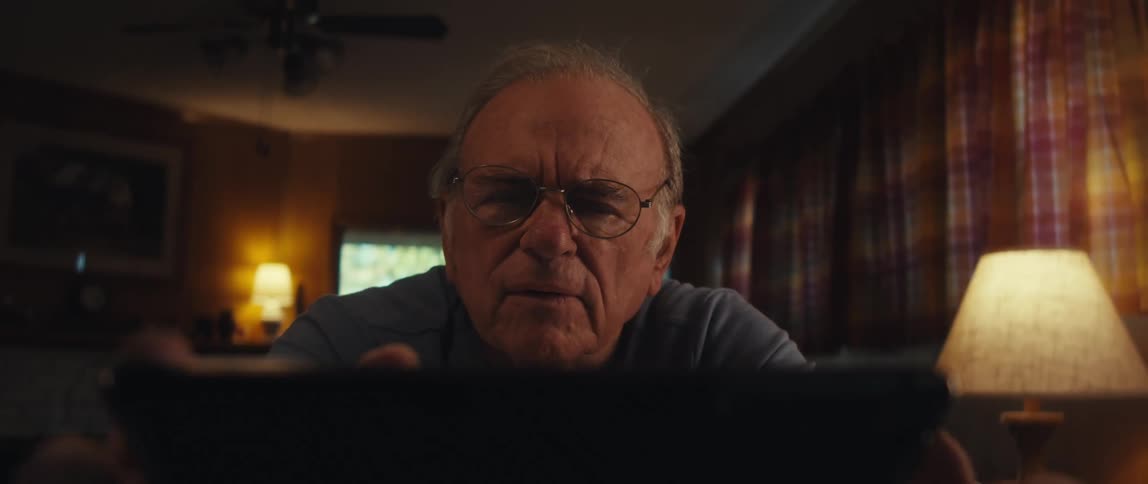 Close up of the face of an elderly man using a tablet at home