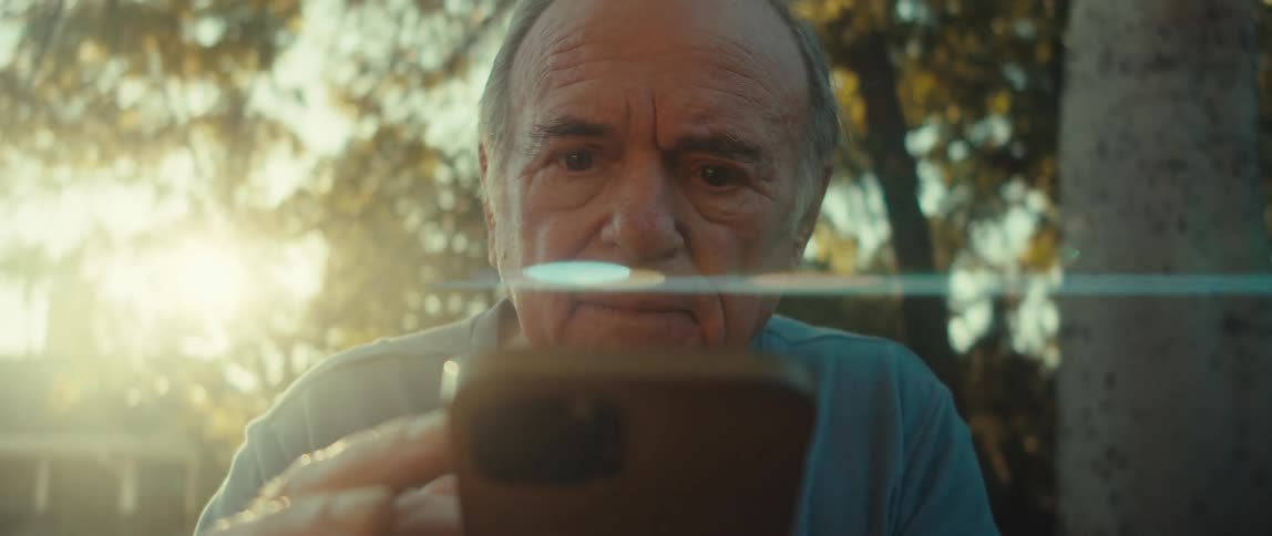 Elderly man getting surprised while using a smartphone