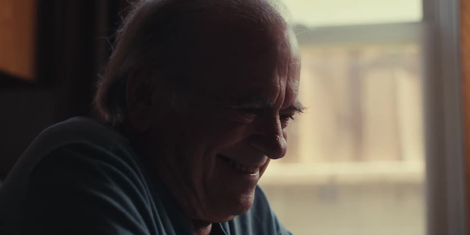 The face of an elderly man looking straight ahead and smiling
