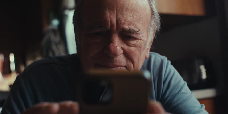 Elderly man interacting with an iphone