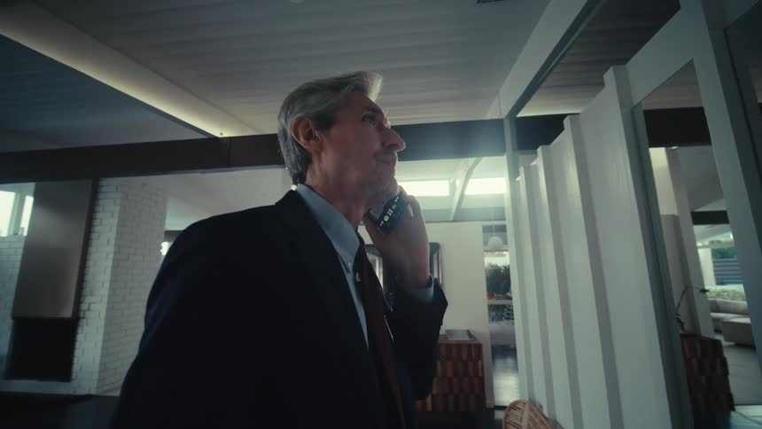 Man facing a mirror on a phone call