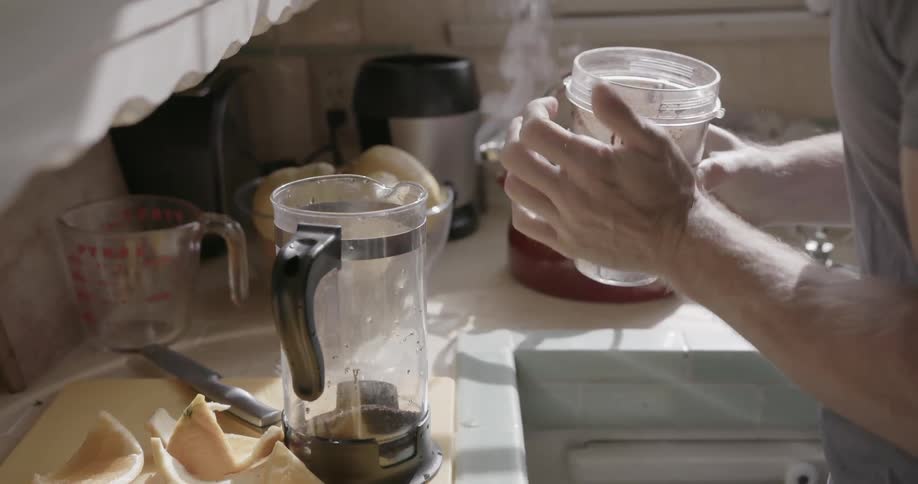 A person dumps coffee grounds into a press