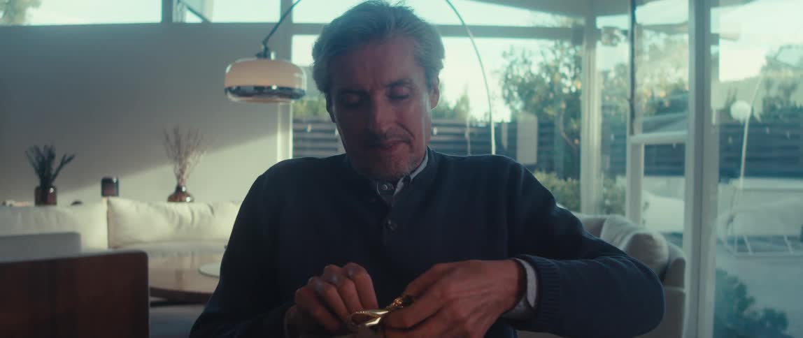 Man sitting in a chair finishing wrapping a gift