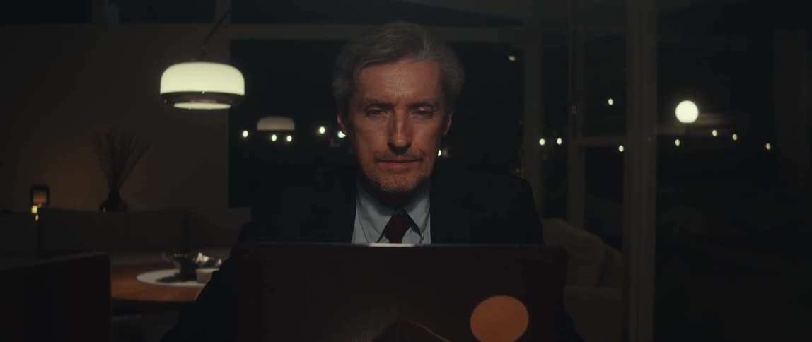 Man sitting in a room at night using his laptop