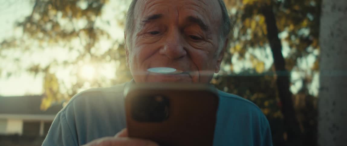 Portrait of a happy senior man outdoors using a smartphone