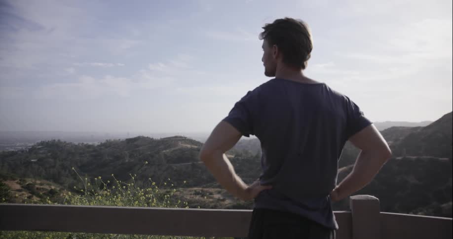 A man looks out from atop a mountain
