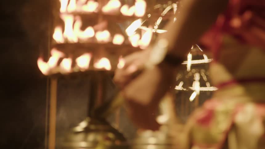 Performers swing bronze objects covered in fire