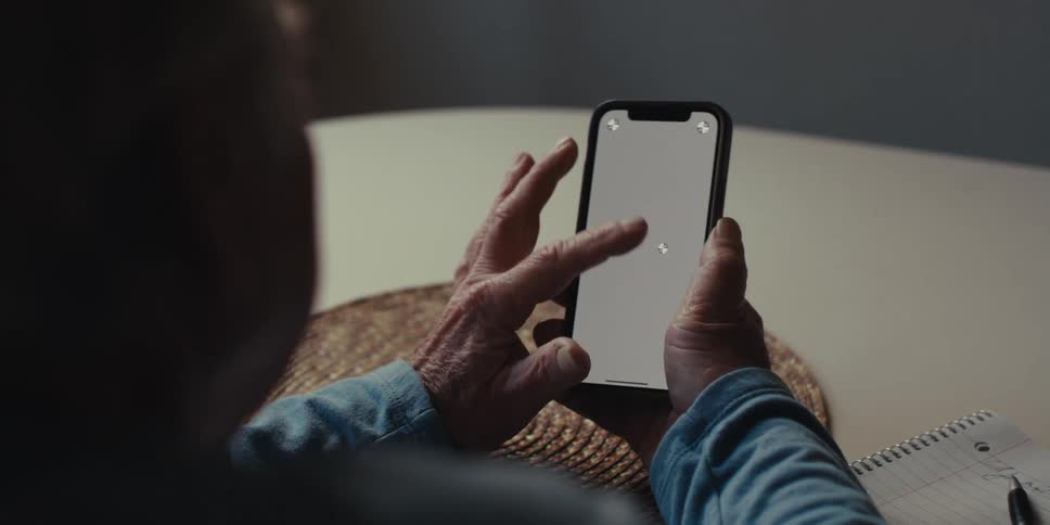 Hands of an elderly person using a smartphone