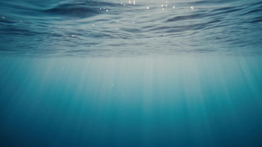 Sunlight is shining underneath the ocean water