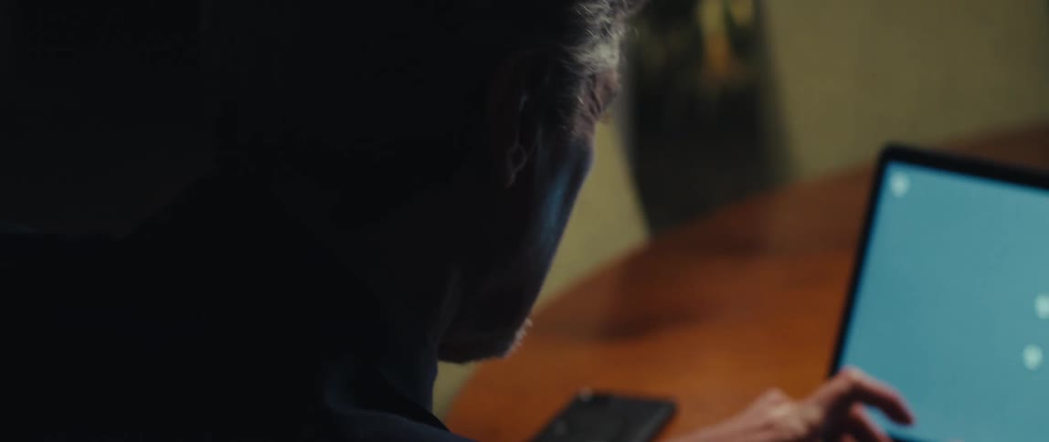 A man is using a laptop with a blue replaceable screen