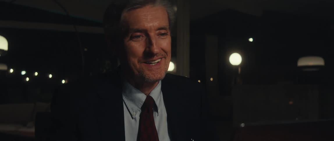 A man smiles and talks