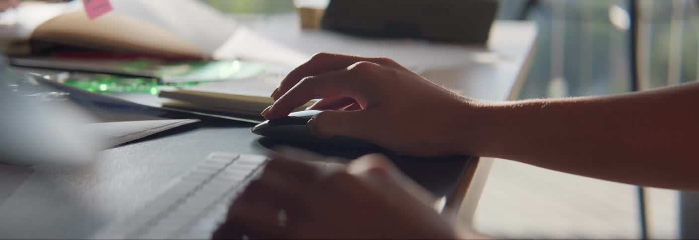 Hands of a person interacting with a computer mouse